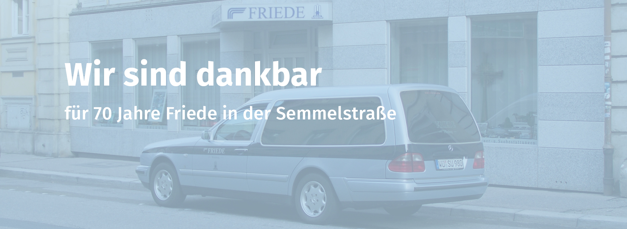 Bestattungswagen vor Bestattungen Friede Standort mit Text: Wir sind dankbar für 70 Jahre Friede in der Semmelstraße